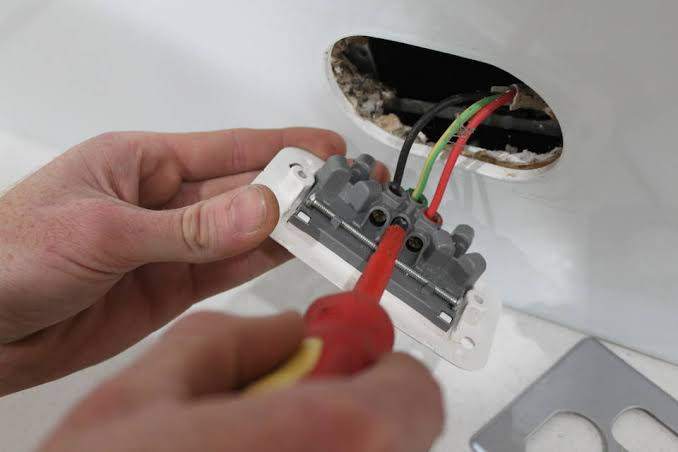 an electrician wiring a power socket